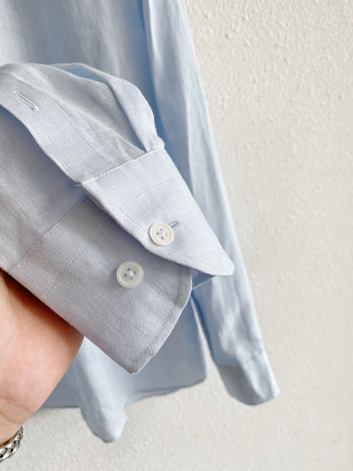 Loro Piana pure linen quiet luxury long-sleeved shirt Fabric: Select high-grade natural linen fabrics, retaining the original and delicate fabric texture of linen, with a soft matte texture, in line with the Italian style of low-key quiet luxury; The fabric has rich pores and excellent Breathable heat dissipation performance. In midsummer, the upper body can quickly dissipate body surface heat, making daily travel less prone to sweating and sticky skin; Native linen will produce natural light wrinkles, creating a casual and relaxed wearing atmosphere. The fabric has been pre-processed and optimized, and the rough and itchy feeling has been greatly weakened, making it comfortable to wear against the skin. The color fastness of the fabric has been controlled, and light colors are less prone to yellowing and dullness after repeated washing and care. Style and details: It adopts an elegant Italian small square collar with built-in shaping technology, which is not easy to fall and deform after daily wear and cleaning; the buttoned neckline is suitable for light business scenes, and you can switch to daily casual style by loosening the two upper buttons; the tailoring adopts a slightly loose shoulder version, which is very tolerant for figures with slippery shoulders, large shoulder width, and fat on the waist and abdomen. The shoulders are neatly routed, and the upper body does not feel tight and restrictive; The buttons on the placket are neatly arranged, and the wiring is fine and concealed. There is no conspicuously exposed brand logo, and the details are restrained and restrained; the regular-length long-sleeved cuffs can be folded freely, which can create different looks; the arc-shaped hem design is suitable for multiple wearing methods. It can be worn neatly and smartly when tucked into trousers, while the hem can be worn outside for a lazy and comfortable look. Color selection: Light sky blue: The tone is fresh and clear, with outstanding visual cooling effect. It is suitable for spring and summer seasons. It is suitable for all types of Light Gray, Khaki, and White bottoms. It is refreshing and neat for commuting, and suitable for more formal travel occasions; Oatmeal: the natural color of linen, with a warm and soft texture, stronger stain resistance, and a higher fault tolerance rate for daily wear. It is suitable for leisure travel, daily shopping and other scenes, and has a strong sense of old money. Sizes:M-4XL